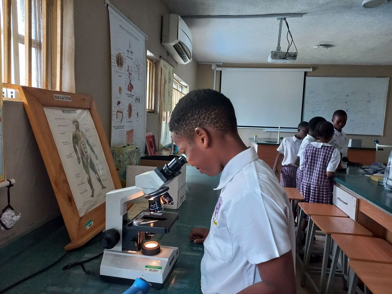 Pupil using a microscope in the science laboratory